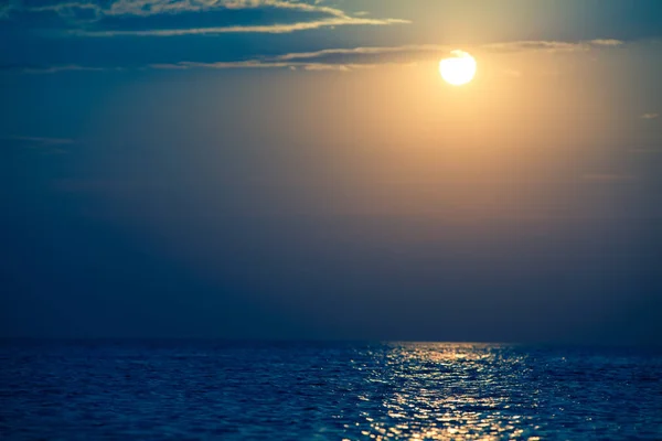 Морской пейзаж неподвижной поверхности моря, золотой закат в небе — стоковое фото