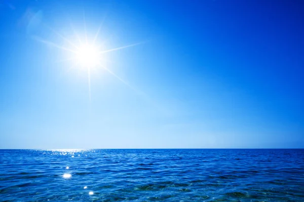 Wybrzeże spokojnej powierzchni morza, złote słońce na niebie — Zdjęcie stockowe