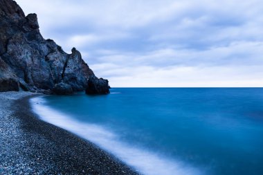 Yazın Kırım 'da dalgalı fırtınalı Karadeniz kıyısında güzel bir gün batımı.