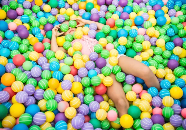 Child lying in pool with plastic balls — 스톡 사진