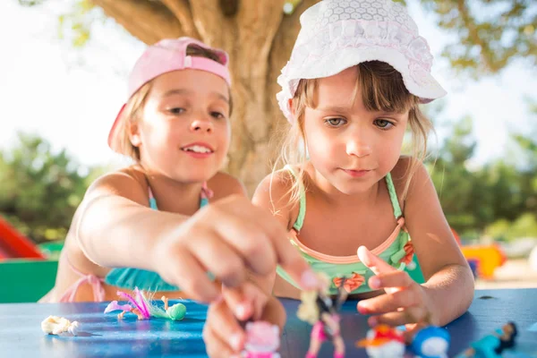 Dışarıda oyuncak bebeklerle oynayan iki küçük tatlı kız. — Stok fotoğraf