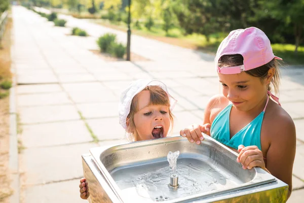 Carino ragazze assetate beve acqua dal lavandino — Foto Stock