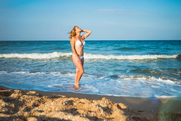 Belle jeune femme heureuse se tient debout sur du sable humide — Photo