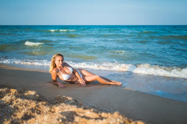 Hermosa joven feliz está acostada en la arena mojada —  Fotos de Stock