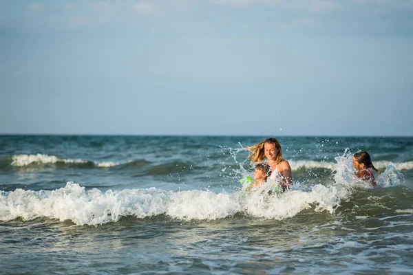 Веселая молодая мать плавает в море — стоковое фото