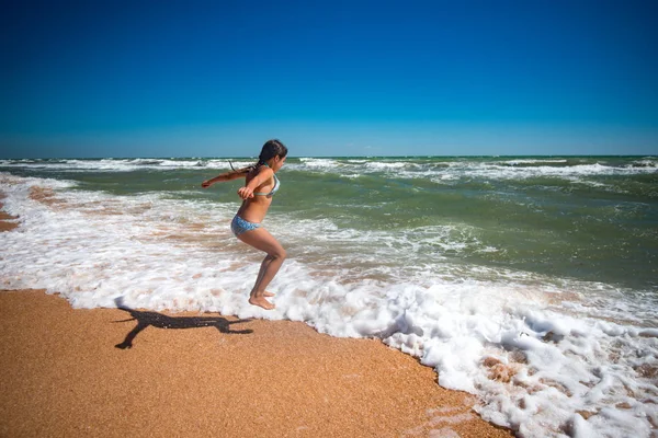 Alegre pouco ativo menina pulando no o ondas — Fotografia de Stock