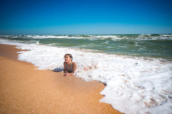 Pleased pretty little girl enjoys warm sea water — 스톡 사진