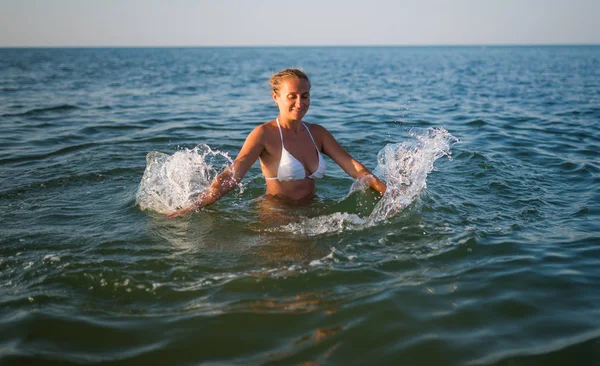 Bakifrån av vacker ung kvinna simmar i havet — Stockfoto