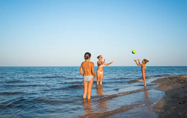 Pretty young woman plays ball with her daughters — Stock Photo, Image