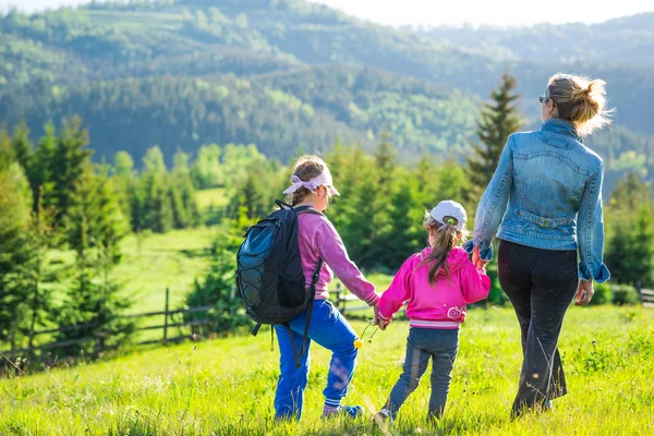 Arkadan bakınca anne ve iki kızı var.