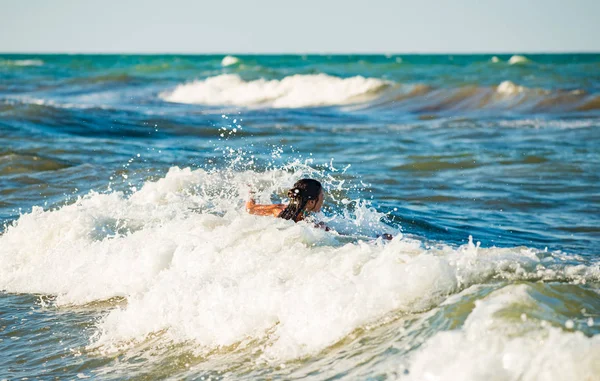 Feliz niña emocional se baña en las olas del mar — Foto de Stock
