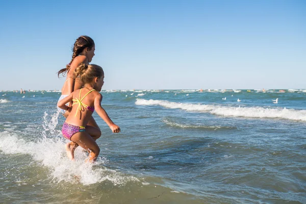 Les petites filles positives courent le long des vagues orageuses — Photo