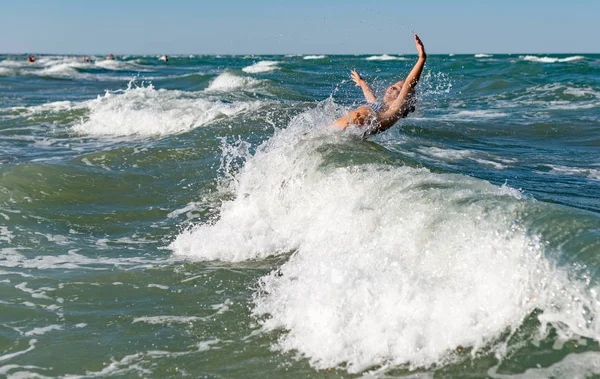 Pequeña chica activa divertida salpicando en el mar ruidoso — Foto de Stock