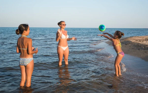 Pretty young woman plays ball with her daughters — Stock Photo, Image