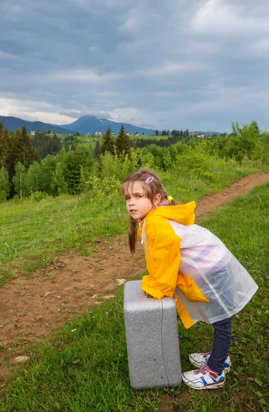 Чарівна маленька дівчинка мандрівник у дощовому костюмі — стокове фото