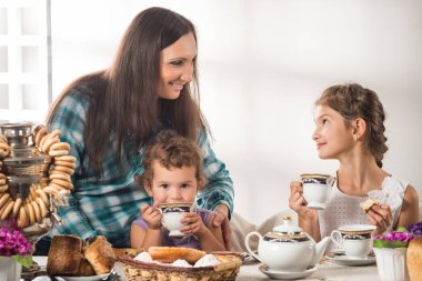 Sevimli şefkatli anne küçük tatlı oğluna çay doldurur.