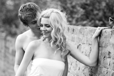 Genç çift yürürken sarılıyor.