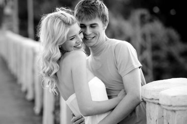 Genç çift yürürken sarılıyor.