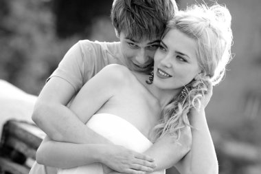 Genç çift yürürken sarılıyor.