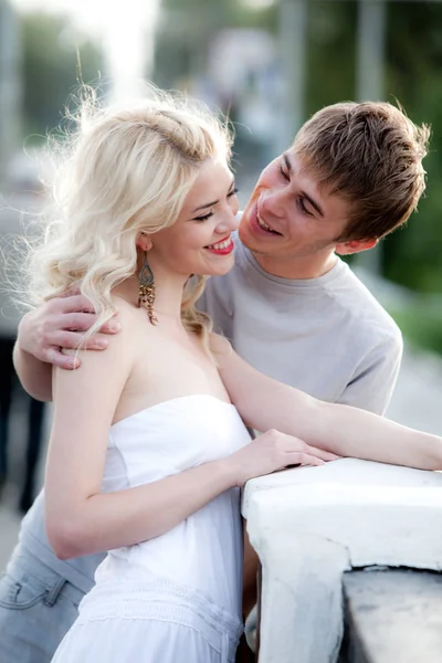 Genç çift yürürken sarılıyor.