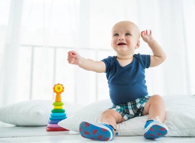 Altı aylık güzel bir çocuk oturur.