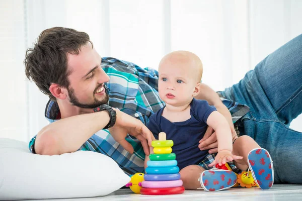 Positivo jovem pai senta-se com seu pequeno filho — Fotografia de Stock