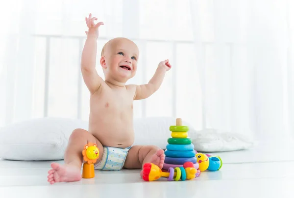 Ragazzo allegro affascinante in un pannolino ride — Foto Stock