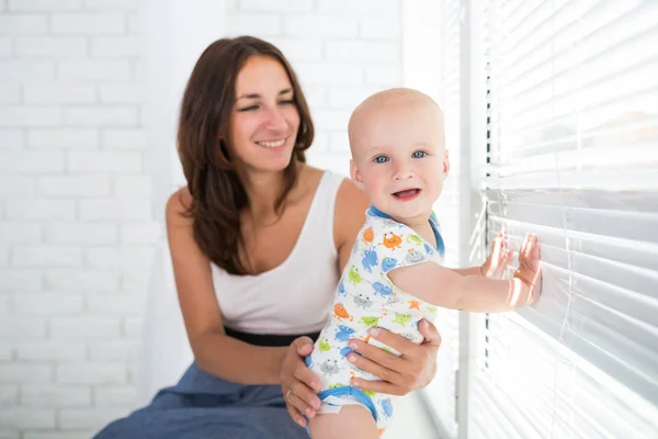 Pequeno menino alegre bonito com uma mãe carinhosa feliz — Fotografia de Stock