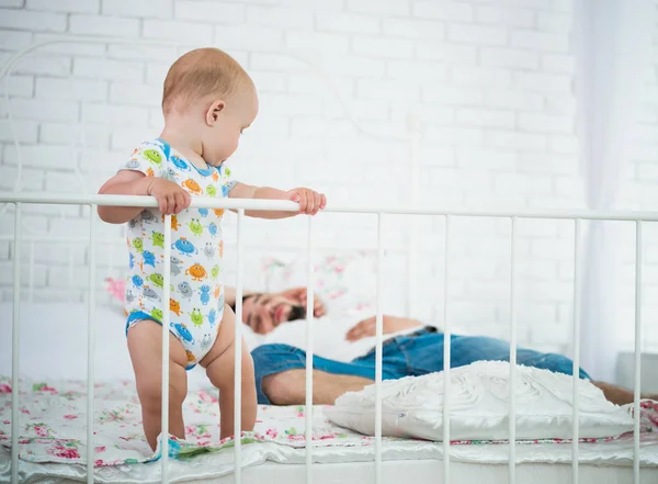 Cute little baby is standing on the edge of bed — 스톡 사진