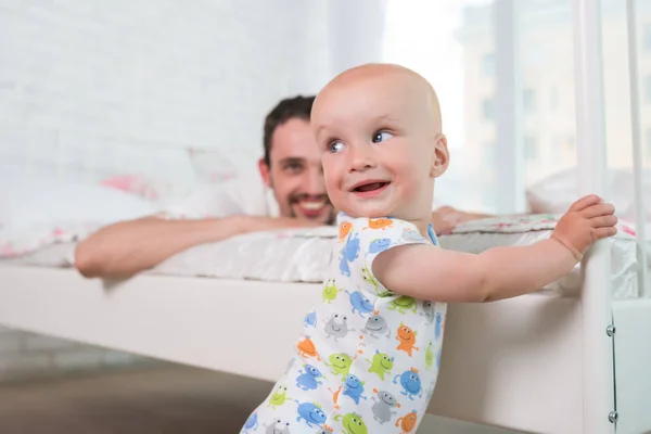 Cute little baby is standing on the edge of bed — 스톡 사진