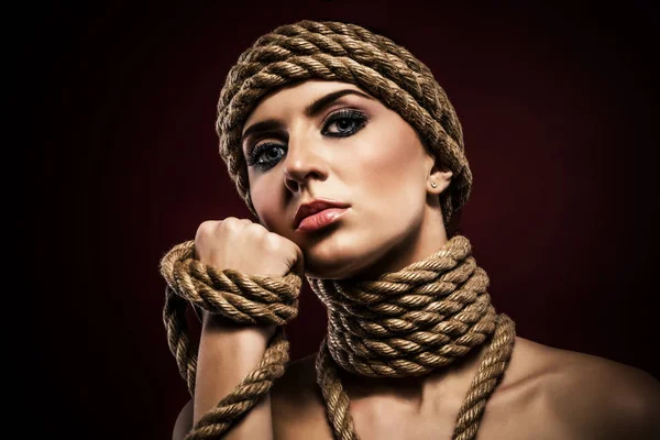 Portrait of a pretty young woman with ropes