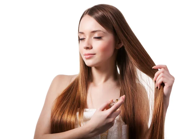 Girl with brown hair spraying perfume on her wrist — 스톡 사진