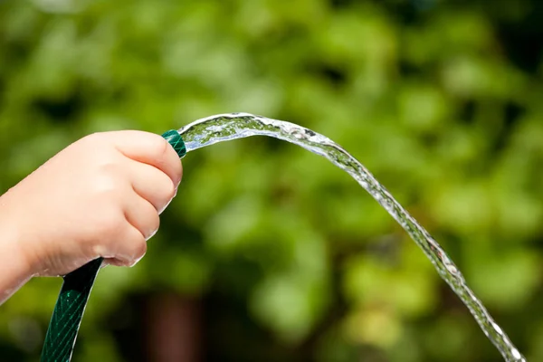 Spritzwasser aus Kinderhand — Stockfoto