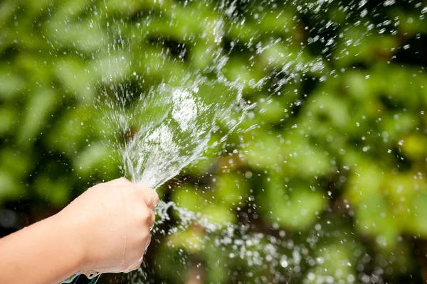 Spritzwasser aus Kinderhand — Stockfoto