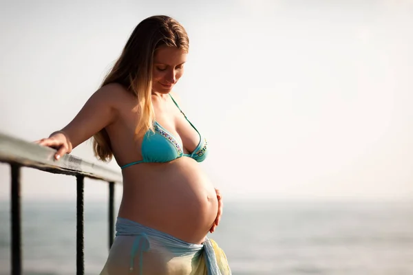 Pregnant women dressed in swimming suit near sea — 图库照片