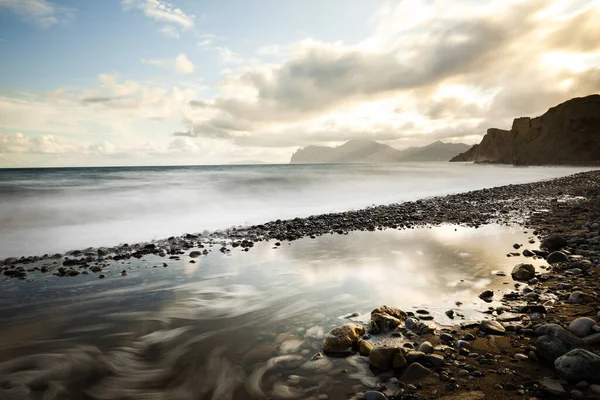 Playa de arena con montañas y cielo nublado — Foto de Stock