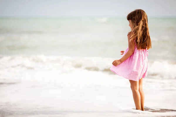 Chica con el pelo castaño saltando en la orilla del mar —  Fotos de Stock