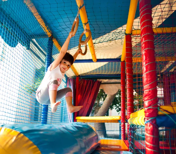 Дівчина висить на барвистому дитячому майданчику — стокове фото