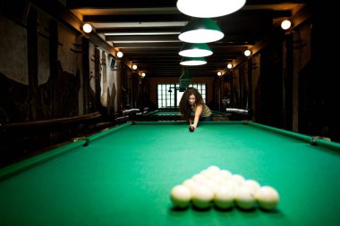 Beautiful girl playing billiards