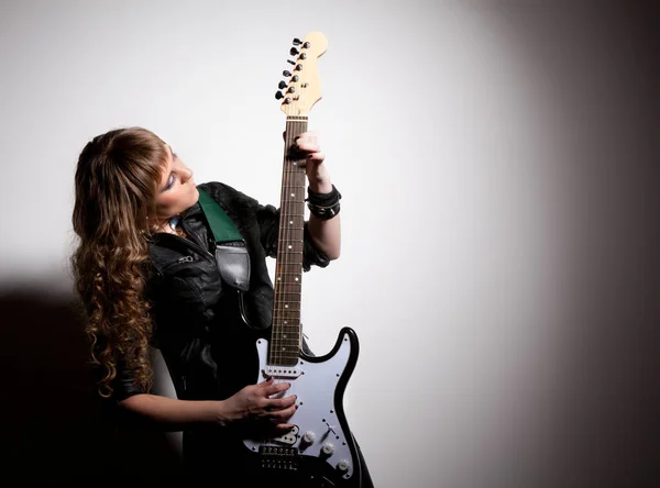 Woman squatting and clutching guitar — Stok fotoğraf