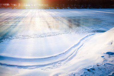 Small frozen river illuminated bright sun