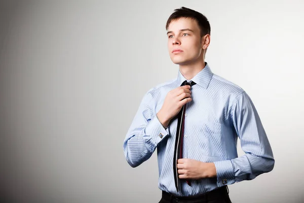 Ένας άντρας με μπλε πουκάμισο ισιώνει τη γραβάτα του — Φωτογραφία Αρχείου