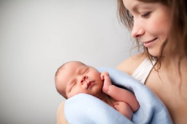 Loving mother holding newborn baby. clipart