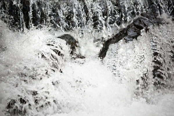Wodospad wylewa się z urwiska do kamieni — Zdjęcie stockowe