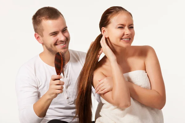 Neşeli genç adam tarıyor kadın saçlarını. — Stok fotoğraf