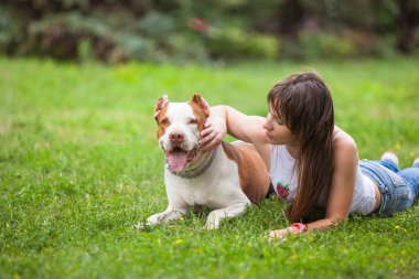 Köpeğiyle çimlere uzanan neşeli bayan..