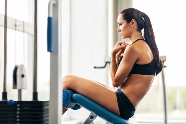 Mujer joven y deportiva haciendo ejercicio en el gimnasio . —  Fotos de Stock