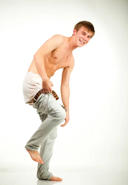 Divertente ritratto di un giovane uomo in forma che si mette i pantaloni con grande sorriso — Foto Stock