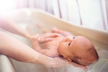 Dikkatli, bilinmeyen bir annenin elleri küçük, güzel, komik bir çocuğu tutuyor. Çocuklar üzerinde bakım ve hijyen kavramı. Çocuklar ve aşk