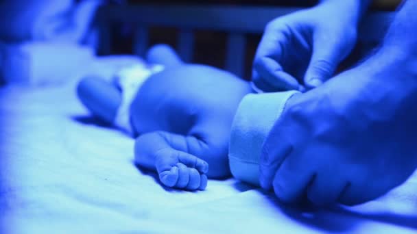 紫外線の下で黄疸の治療を受けた新生児 赤ちゃんはビリルビンの高いレベルを持っています 黄疸のレベルを減らすために青の光の下で敷設 安全な医療方法 — ストック動画